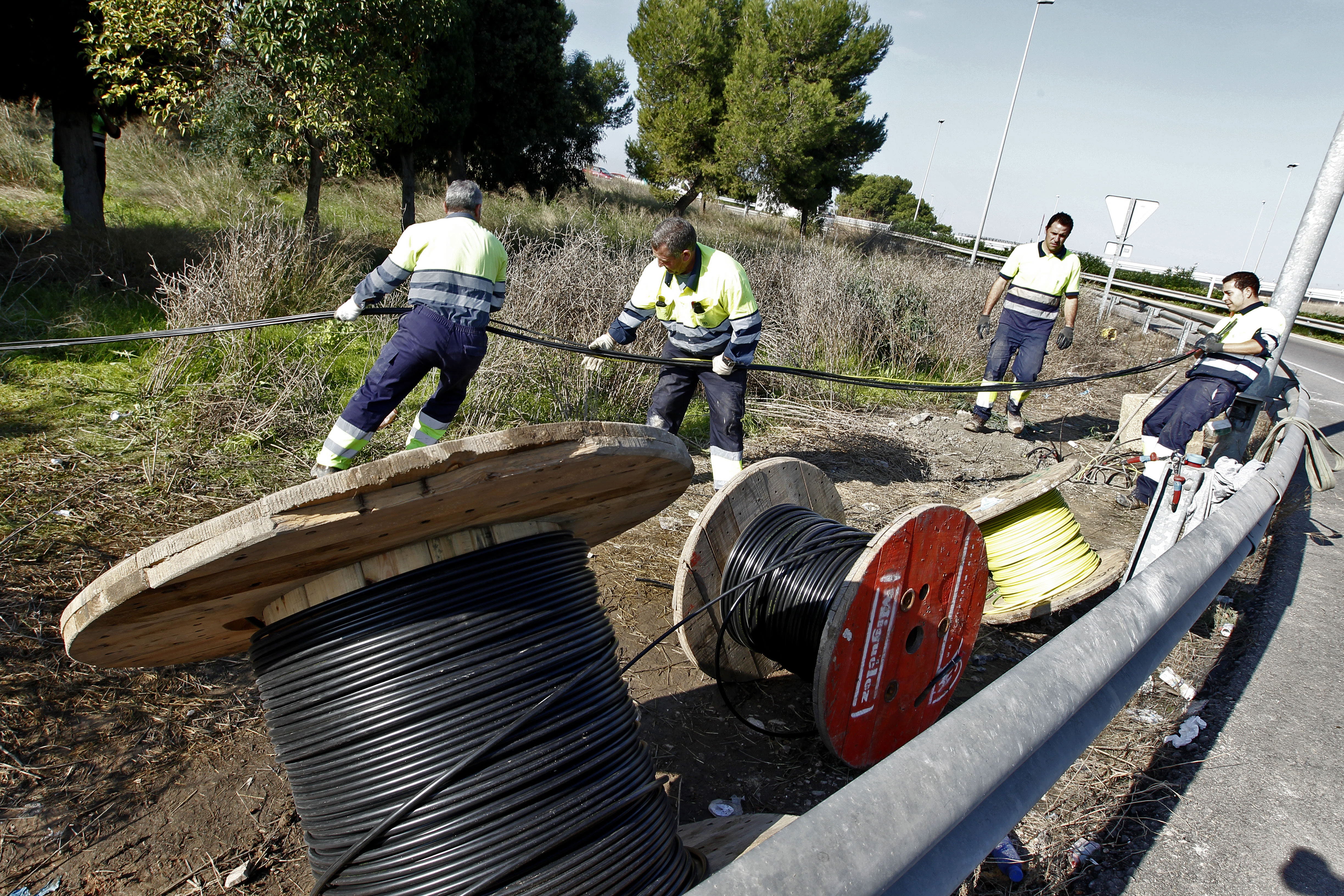 Cuatro trabajadores de la empresa de mantenimiento del alumbrado reponen el cable robado. 