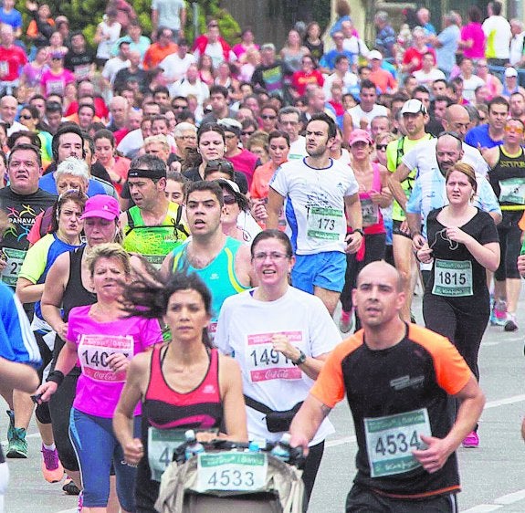 Una pareja empuja un carro de bebé durante la carrera. 