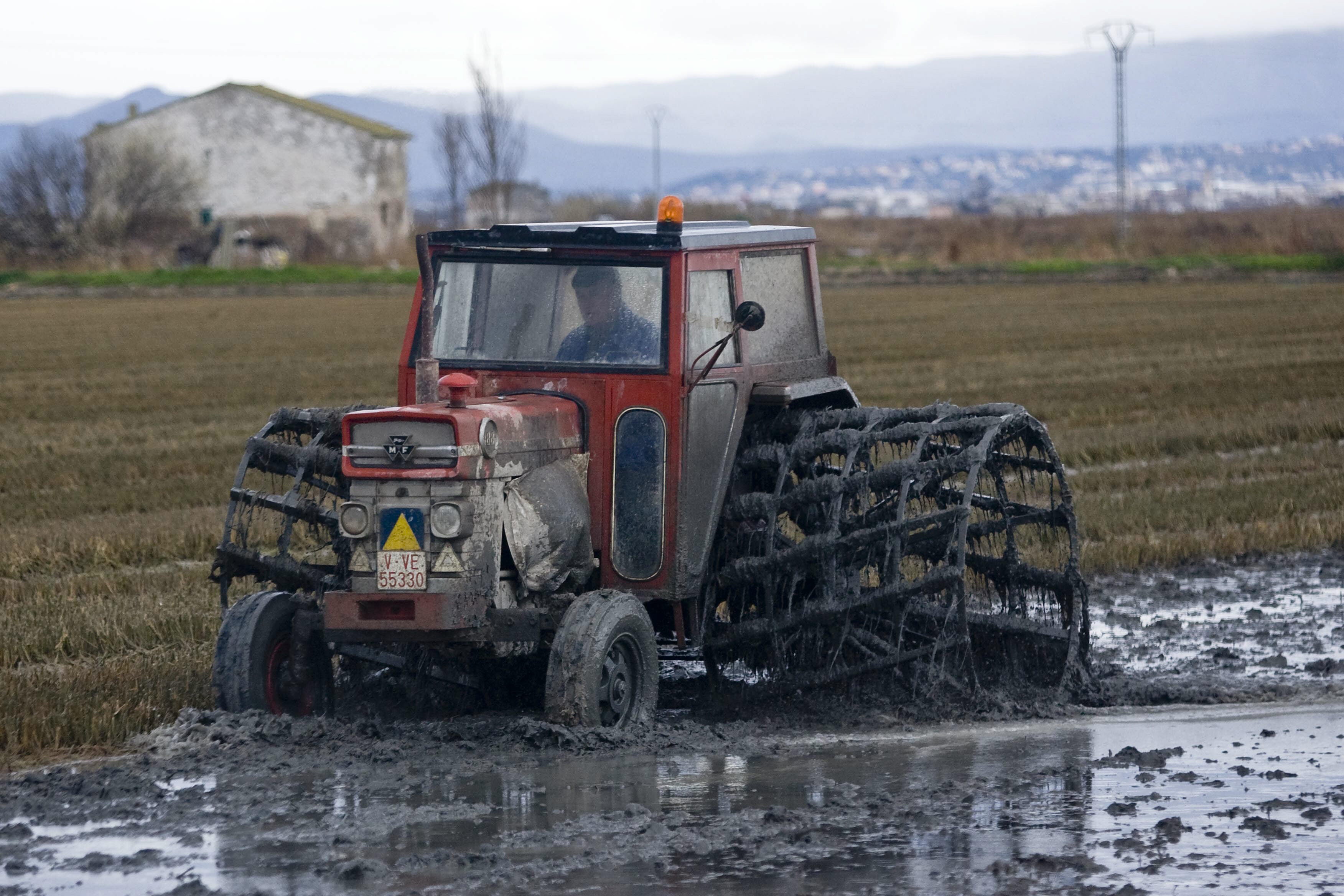 Un tractor removiendo la tierra de los campos de arroz del Parque Natural de La Albufera.