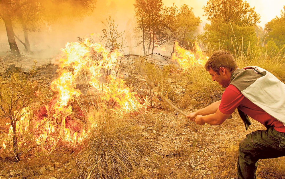 Un hombre trata de apagar el fuego de Andilla.