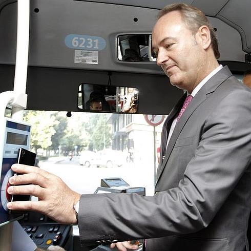 Fabra paga en un autobús con su móvil. 