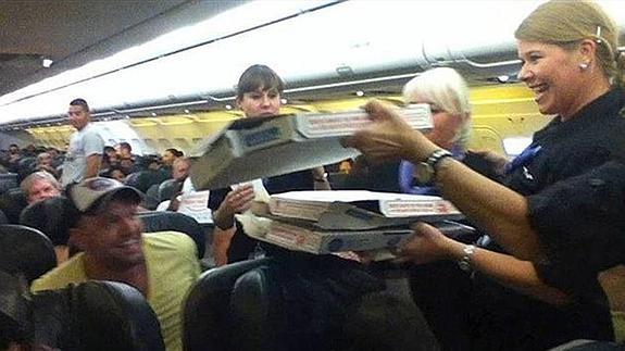 Las azafatas repartiendo las pizzas en el avión.