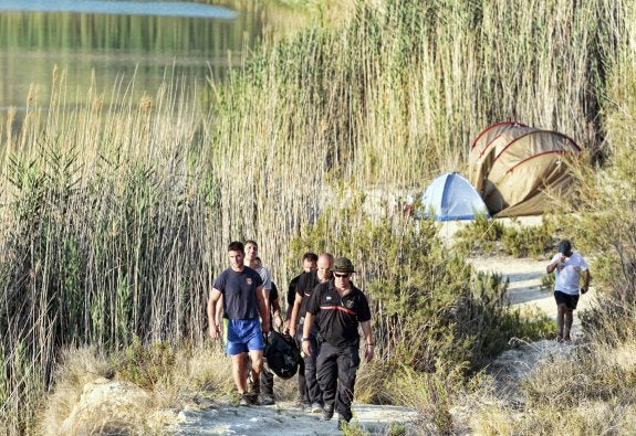 Los servicios de salvamento y rescate transportan el cuerpo sin vida del joven alicantino en la laguna de la Rabassa. :: J. P. REINA