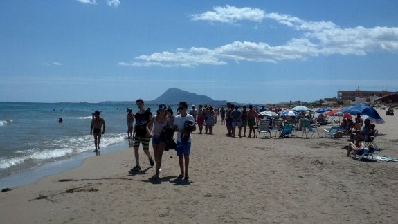 La playa de Les Deveses de Dénia, el domingo por la mañana, repleta de turistas que acudieron a bañarse y dar un paseo. :: lp