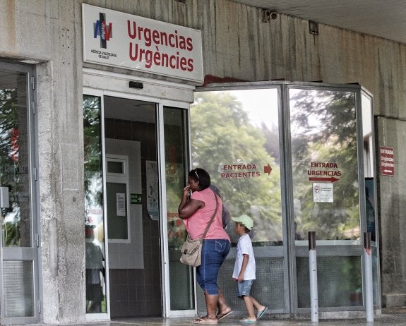 Una mujer entra con un niño a urgencias del Hospital de Alicante. :: j. p. reina