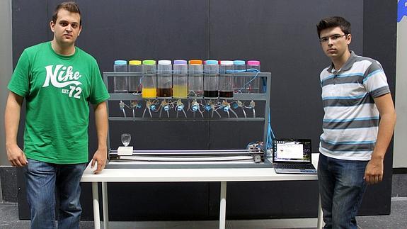 Emilio López Juárez y Juan Carlos Blay Torregrosa junto al robot que prepara cócteles automáticamente.