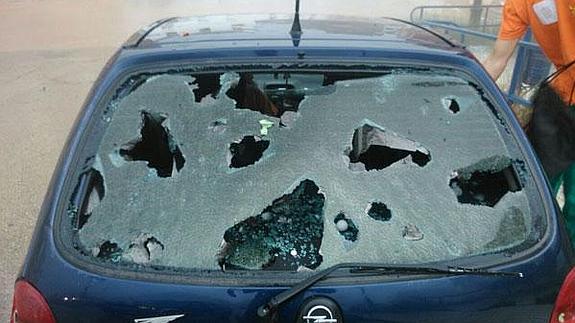 La luna trasera de un coche, destrozada por el granizo.