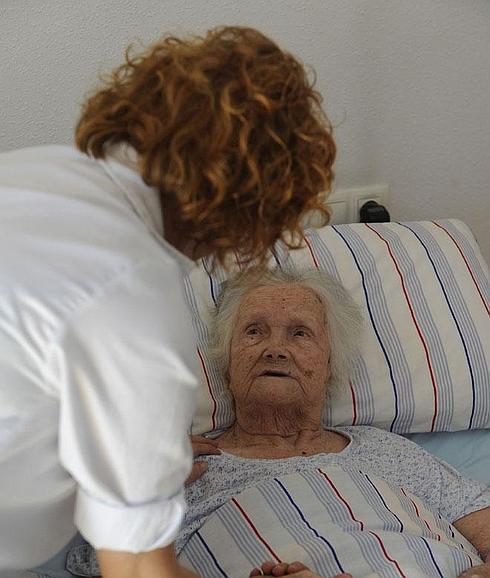 Una anciana, recibiendo atención sociosanitaria.