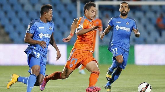 Diego Castro y el colombiano Fredy Hinestroza corren tras el balón junto al delantero del Valencia Rodrigo 