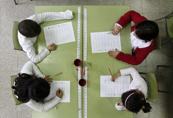 Varios alumnos rellenan una ficha durante una clase. :: albert gea/reuters