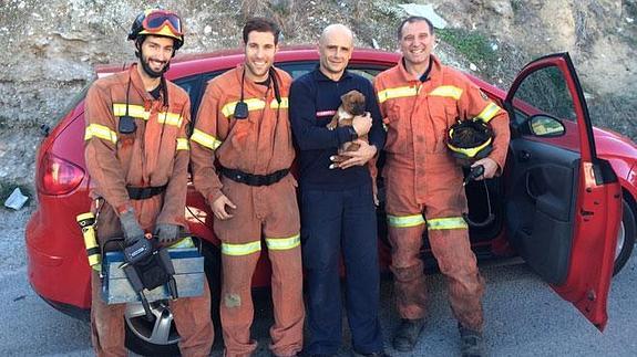 Los bomberos, tras la liberación del cachorro.