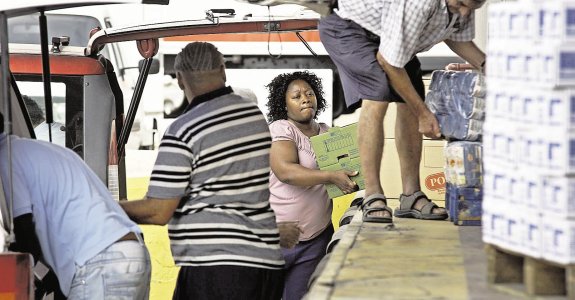 Voluntarios de Cáritas descargan alimentos para destinarlos a la acción social.  :: LP