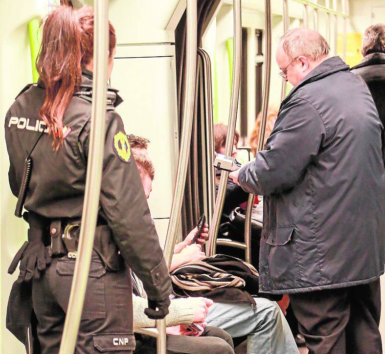 Una policía acompaña a un revisor en el metro.