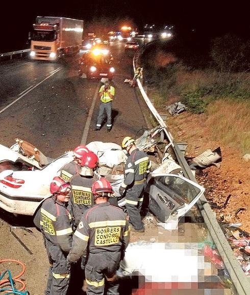 Varios bomberos rodean el coche en el que murieron cinco senegaleses en Alcalà de Xivert.