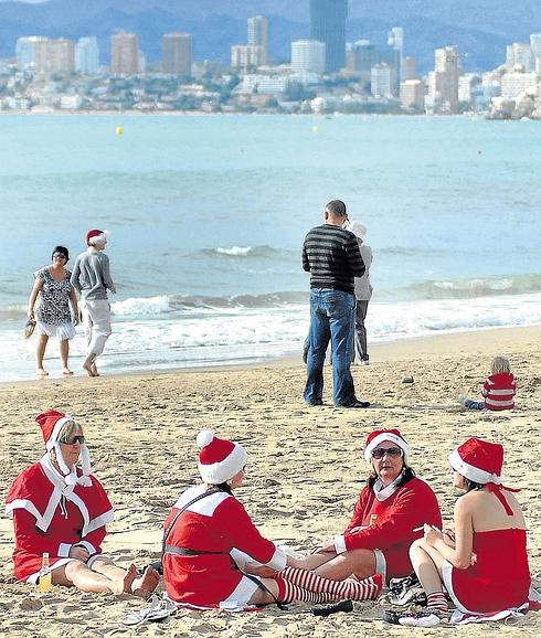 Turistas vestidas de Papá Noel en la playa de Benidorm el día de Navidad. 