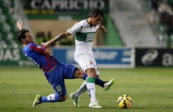 Rubén García trata de robar el balón a Damián Suárez durante el partido de ayer en el Martínez Valero.