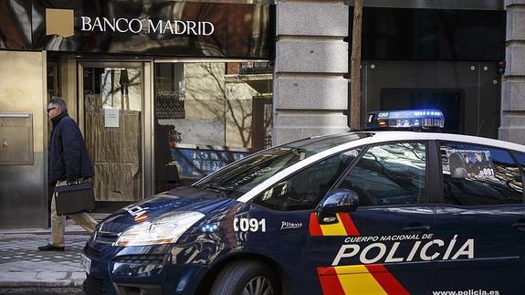 Un coche de policía, en la puerta del Banco Madrid. 