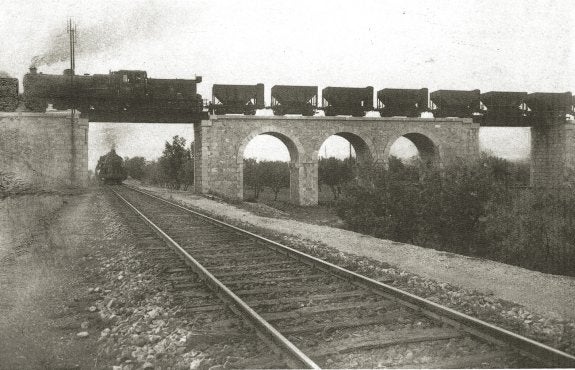 CRUCE DE LAS DOS LÍNEAS  El tren, por encima de la línea Central de Aragón; arriba y derecha, talleres y estación de Sagunto.