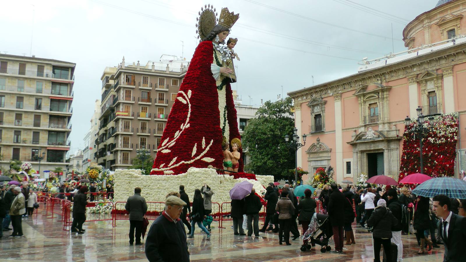 Miles de valencianos acuden a contemplar el homenaje floral a la Mare de Déu a pesar del mal tiempo.