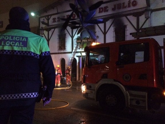 Agentes de la Policía Local y bomberos, durante la extinción de las llamas en el asador. :: lp