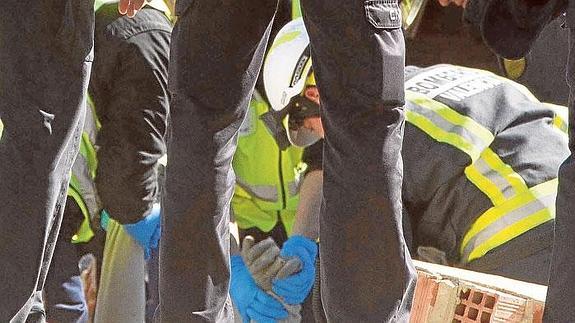 Los bomberos extraen el cuerpo de un hombre al que le cayó un muro mientras trabajaba.