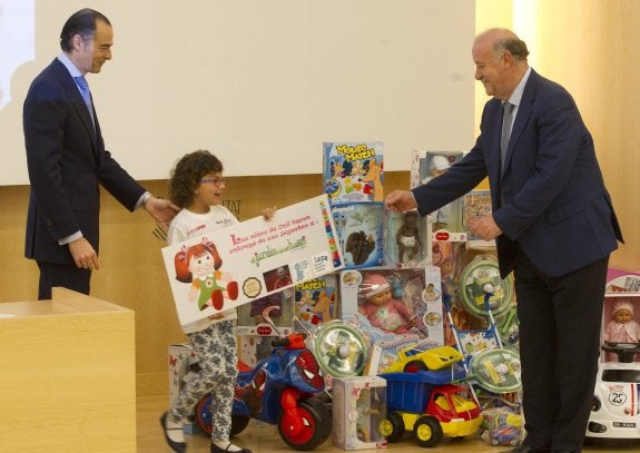 Llombart y Del Bosque entregan un juguete a una niña en La Fe.