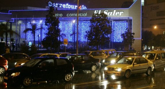 Varios vehículos, junto al centro comercial El Saler, de Valencia, en una noche lluviosa.:: jesús signes