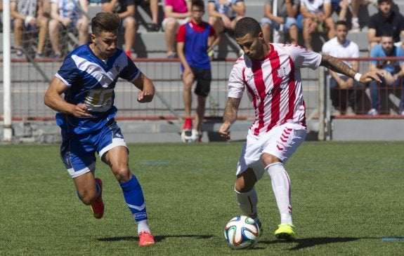 Un jugador del Huracán juega el balón ante la presión de un rival del Badalona. :: damián torres