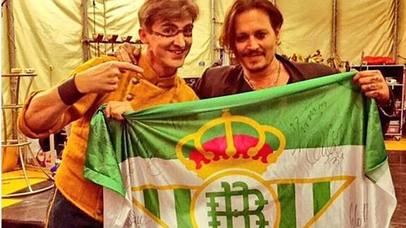 El actor Johnny Depp se fotografía junto a la bandera del Real Betis.