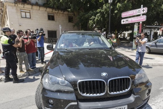 Los agentes, abandonando en un coche de alta gama los alrededores del ayuntamiento de Gandia. ::  EFE/NATXO FRANCÉS