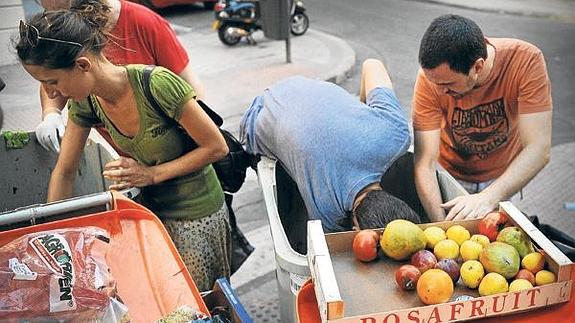 Un grupo de activistas recoge frutas y verduras de unos contenedores en Madrid para demostrar que se tiran alimentos aptos para el consumo.