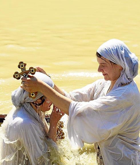 Dos peregrinas ortodoxas se bautizan en las aguas del río Jordán.