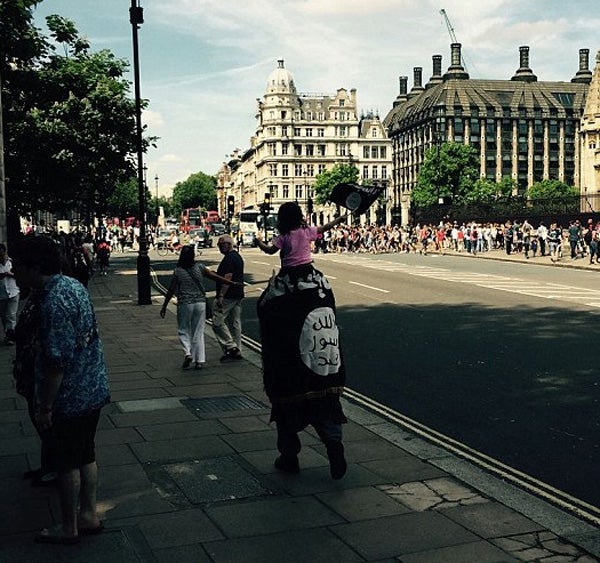 Un hombre y su hija pasean por Londres con la bandera del Estado Islámico