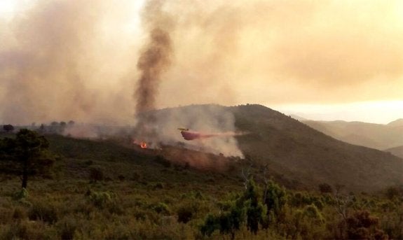 Medios aéreos y brigadas trabajando contra el incendio en la localidad castellonense de Montán. :: efe