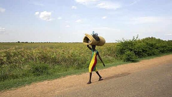 Mujer huye con sus pertenencias de los combates den Bentiu, en el estado Unidad de Sudan del Sur.