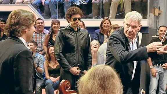 Constantino Martínez Orts, a la izquierda, observa cómo Harrison Ford dirige a su orquesta en el 'Hormiguero'.