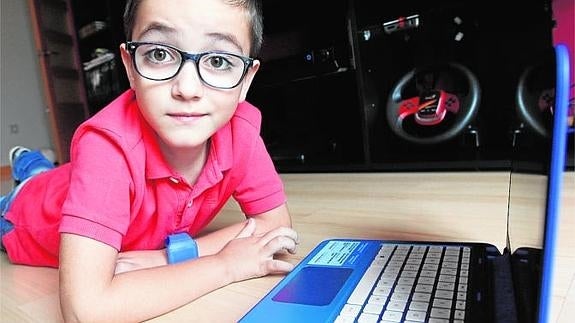 Aitor, el peqeuño programador, en el salón de su casa trabajando con su ordenador.