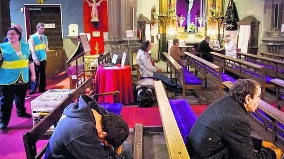 Feligreses de la iglesia de San Antón que pueden acudir las 24 horas. Al fondo, el Padre Ángel en su mesilla.