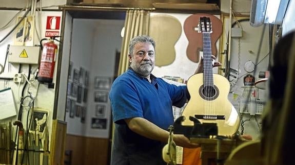 El artesano Miguel Ángel Fernández, en el taller de Pedro de Miguel con un instrumento gemelo al que han hecho para Kerry.