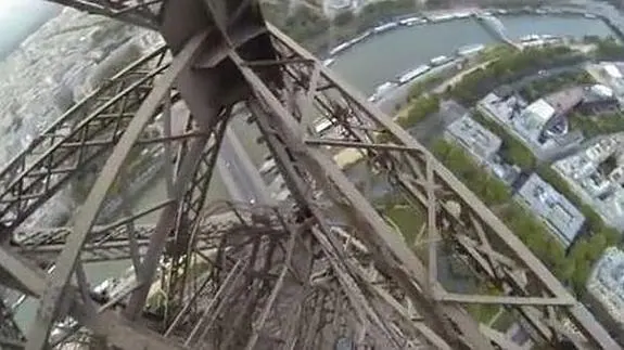 Un joven trepa la Torre Eiffel