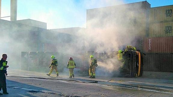 Un camión tráiler vuelca y se incendia en el Puerto de Valencia