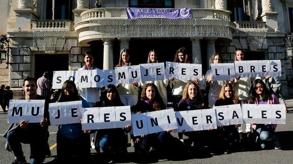 Un grupo de mujeres y hombres conmemora el Dia Internacional contra la violencia machista.