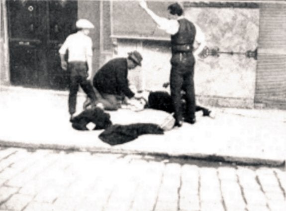 La foto del reportero Gómez Durán fue publicada por la prensa gráfica de Madrid. El guardia civil yace muerto en la acera mientras personal del Hospital intenta atenderle. :: lp