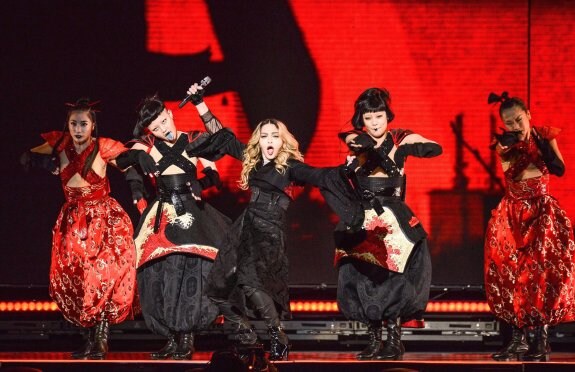 Madonna, durante el concierto en el Taipei Arena. Arriba, el momento en el que se envolvió con la bandera de Taiwán. :: AFP