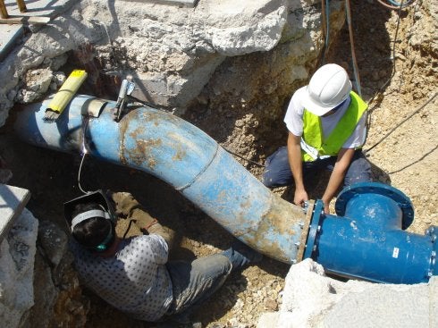 Unos obreros trabajan en una canalización de agua. :: lp