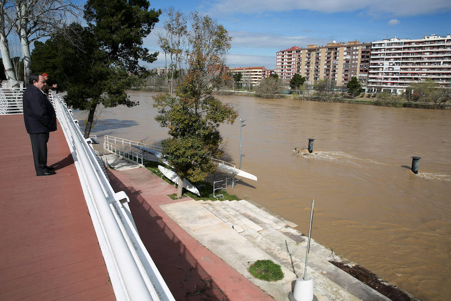 Un hombre observa el nivel del río Ebro a su paso por Zaragoza.