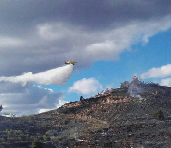 Un avión lanza agua sobre las llamas, ayer en Segart. :: @gva112