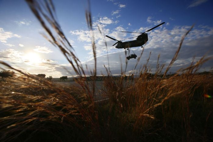 Un helicóptero "Chinook" de las FAMET transporta un vehiculo de las MOE durante unas prácticas de incursión en suelo hostil con helicópteros.