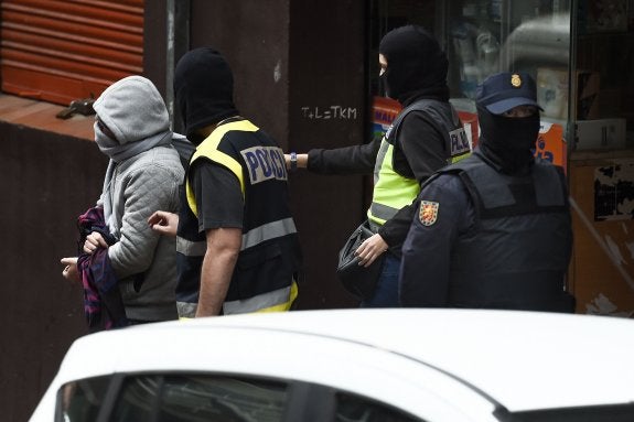 Un policía, con un detenido por terrorismo en Mataró. :: afp