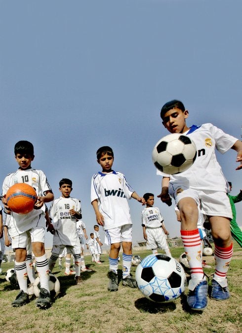 Niños iraquíes vestidos con la equipación del Real Madrid entrenan en una escuela de fútbol en Bagdad, la capital de Irak. :: Faleh Kheiber/efe